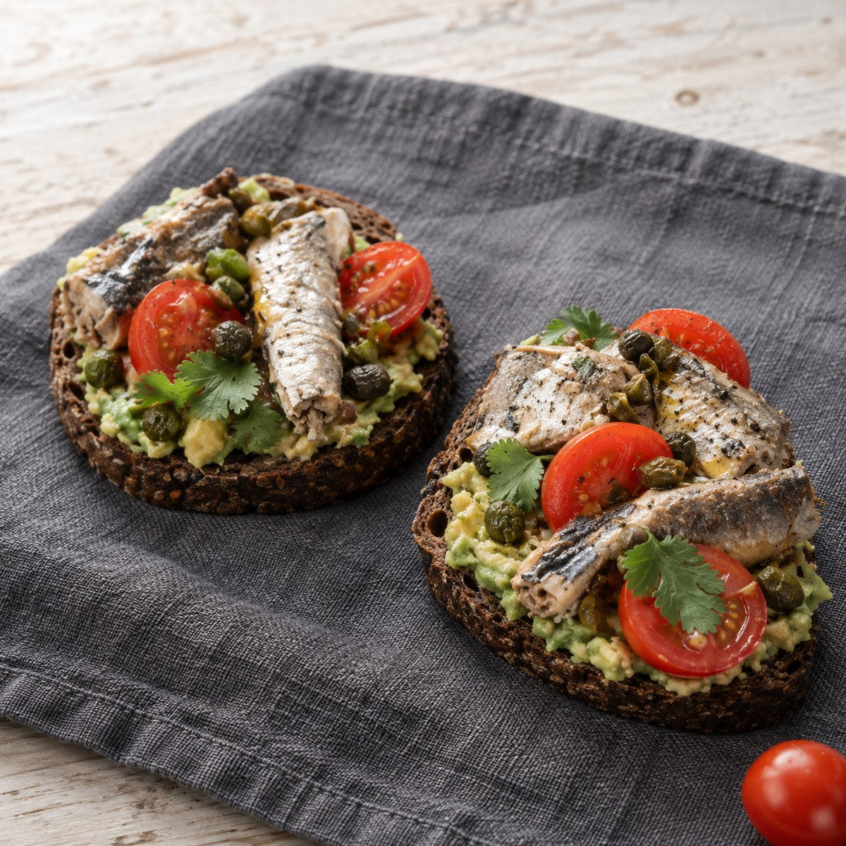 Roggenbrot-Toast mit Avocado, Sardinen, Kirschtomaten und Koriander